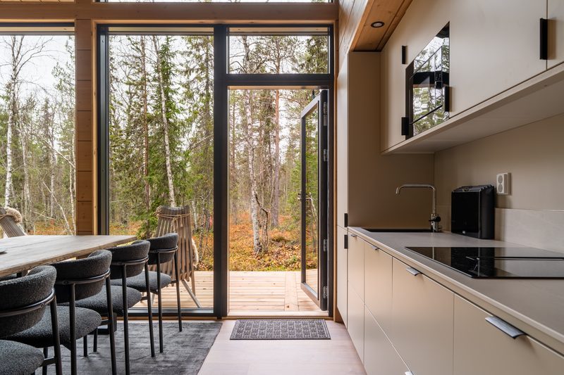 The kitchen worktop and induction hob, with the glass door open onto the deck beside it.